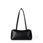 A cognac brown vegan leather baguette shoulder bag with long slim straps and a softly curved top, shown on a white background. Additional product view 2.