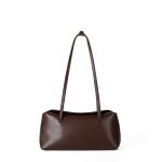 A cognac brown vegan leather baguette shoulder bag with long slim straps and a softly curved top, shown on a white background. Additional product view 3.