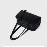 A black pebbled vegan leather Boston bag with long shoulder straps, a top zipper, and a matching leather clochette. Additional product view 7.