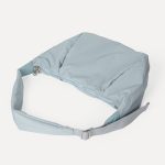 A blush pink padded polyester crescent shoulder bag with a wide adjustable strap and silver zipper, isolated on white. Additional product view 8.