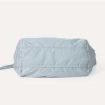 A blush pink padded polyester crescent shoulder bag with a wide adjustable strap and silver zipper, isolated on white. Additional product view 9.