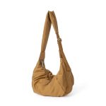 A blush pink padded polyester crescent shoulder bag with a wide adjustable strap and silver zipper, isolated on white. Additional product view 4.