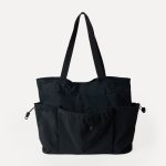 A black crinkled nylon shopper tote with webbing straps and a mid-body drawstring that creates a ruched gathered shape. Additional product view 6.