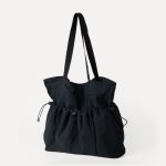 A black crinkled nylon shopper tote with webbing straps and a mid-body drawstring that creates a ruched gathered shape. Additional product view 7.