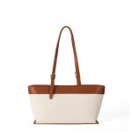 An off-white canvas tote with black vegan leather top trim, base, and adjustable shoulder straps. Additional product view 4.