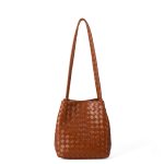 A black woven vegan leather bucket shoulder bag with matching tubular straps and a tight diagonal intrecciato weave. Additional product view 4.