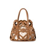 A black laser-cut vegan leather cage tote with a cream drawstring inner pouch and two matching top handles. Additional product view 3.