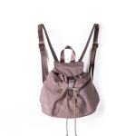 A small black nylon backpack with a drawstring flap, translucent buckle, angled front pocket, and webbing shoulder straps. Additional product view 3.