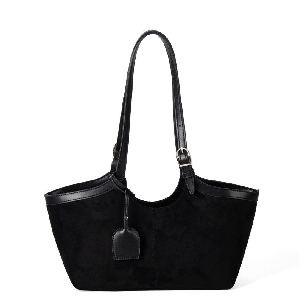 A black faux suede tote with a scooped top, smooth vegan leather trim, and adjustable buckled shoulder straps.