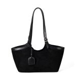 A black faux suede tote with a scooped top, smooth vegan leather trim, and adjustable buckled shoulder straps.