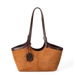 A black faux suede tote with a scooped top, smooth vegan leather trim, and adjustable buckled shoulder straps. Additional product view 2.