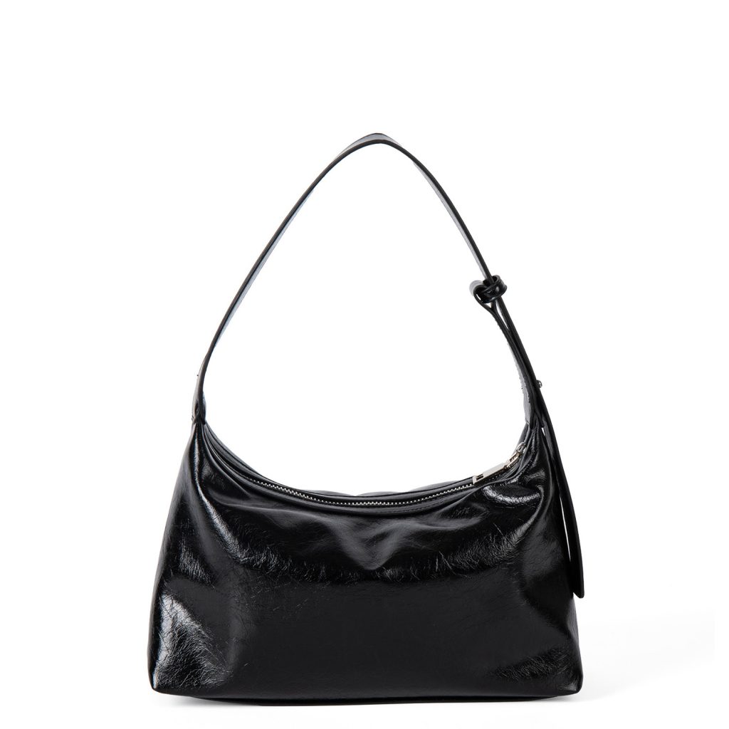 A glossy black crinkled vegan leather crescent underarm bag with a knotted side strap and a silver zipper pull.