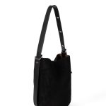 A tall cognac brown faux suede bucket bag with an adjustable vegan leather shoulder strap hanging against a white backdrop. Additional product view 2.