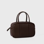A boxy black pebbled vegan leather mini Boston bag with rolled top handles and long zipper pulls. Additional product view 5.