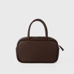 A boxy black pebbled vegan leather mini Boston bag with rolled top handles and long zipper pulls. Additional product view 6.