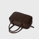 A boxy black pebbled vegan leather mini Boston bag with rolled top handles and long zipper pulls. Additional product view 8.