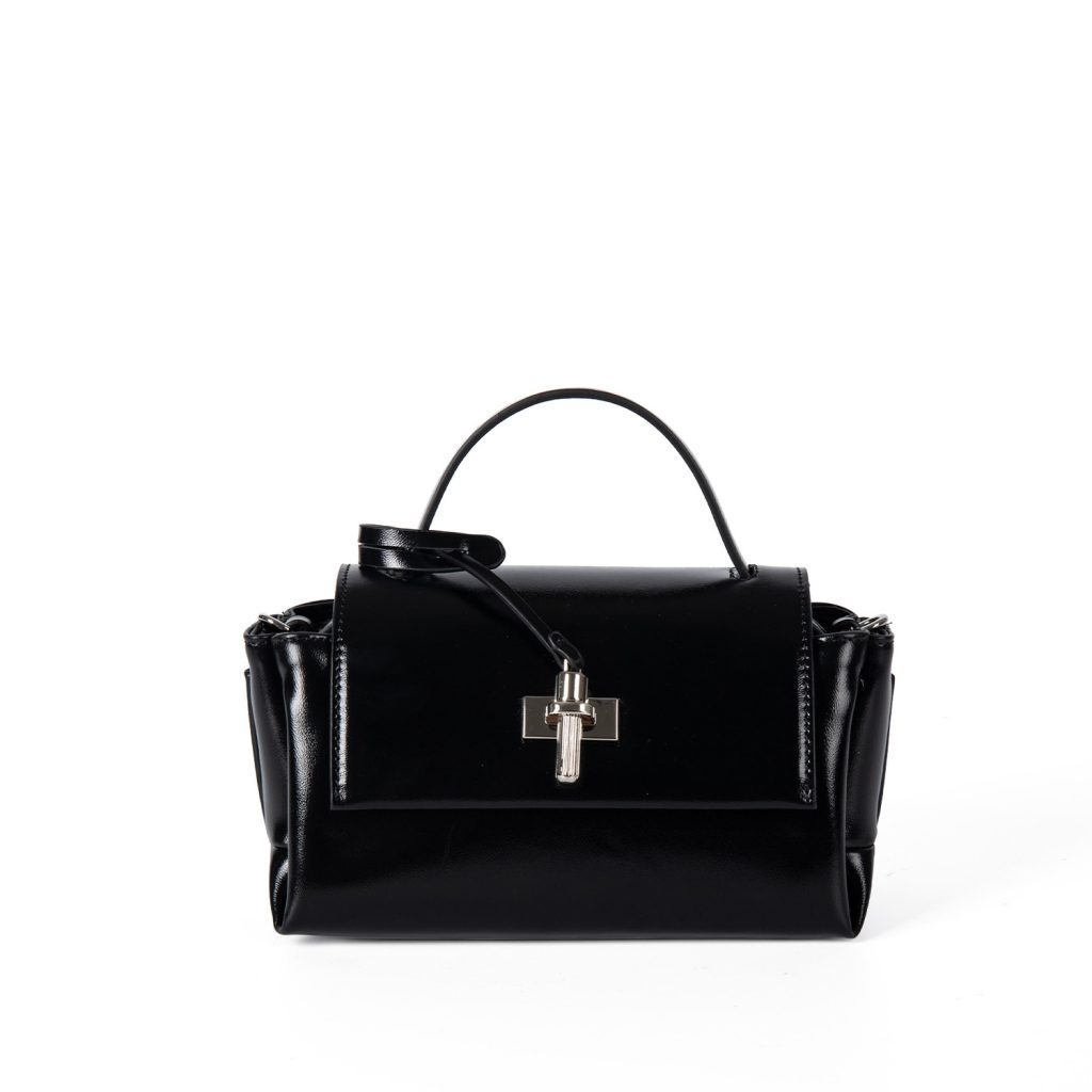 A glossy black structured vegan leather handbag with a thin top handle and a silver cross-bar toggle clasp.