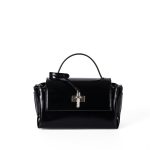 A glossy black structured vegan leather handbag with a thin top handle and a silver cross-bar toggle clasp.