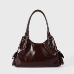 A shiny black vegan leather hobo shoulder bag with a row of silver studs, side flap pockets, and a hanging heart charm. Additional product view 6.