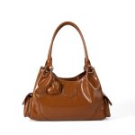 A shiny black vegan leather hobo shoulder bag with a row of silver studs, side flap pockets, and a hanging heart charm. Additional product view 3.