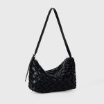 A black basketweave vegan leather crescent underarm bag with a slim adjustable strap and a silver top zipper. Additional product view 6.