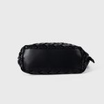 A black basketweave vegan leather crescent underarm bag with a slim adjustable strap and a silver top zipper. Additional product view 8.