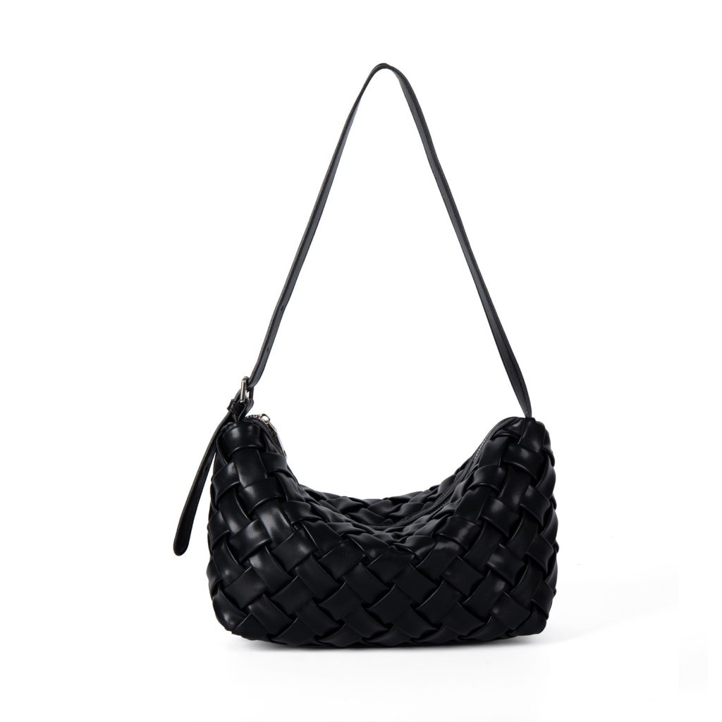 A black basketweave vegan leather crescent underarm bag with a slim adjustable strap and a silver top zipper.