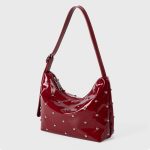 A glossy black vegan leather crescent bag covered in small silver studs, with an adjustable strap and top zipper. Additional product view 4.