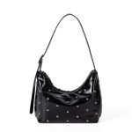 A glossy black vegan leather crescent bag covered in small silver studs, with an adjustable strap and top zipper.