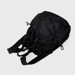 A black nylon drawstring backpack with ruffled cinch opening, side pockets, webbing straps, and a small top handle. Additional product view 8.