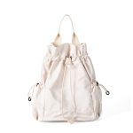 A black nylon drawstring backpack with ruffled cinch opening, side pockets, webbing straps, and a small top handle. Additional product view 2.