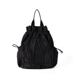 A black nylon drawstring backpack with ruffled cinch opening, side pockets, webbing straps, and a small top handle. Additional product view 3.