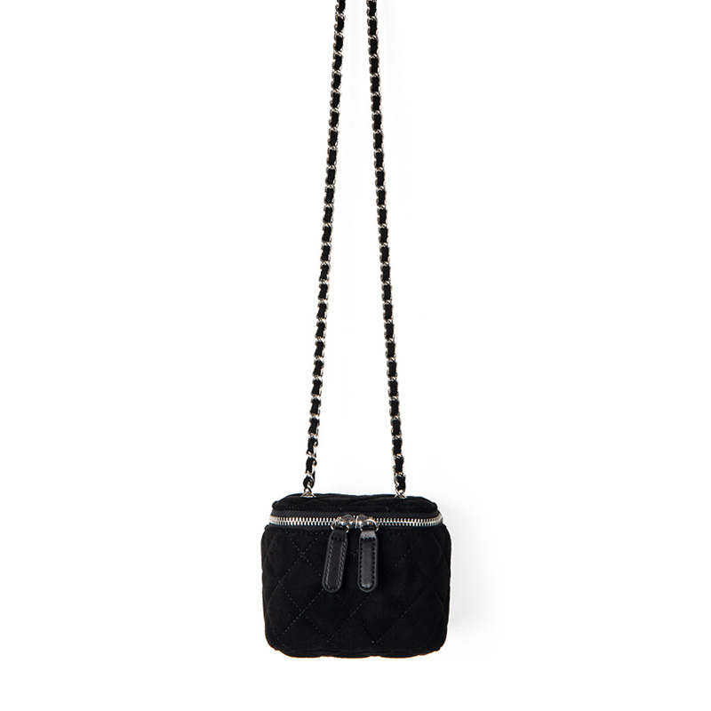 A small black quilted faux suede vanity box bag with dual silver zippers and a chain strap interwoven with black cord.