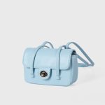 A dusty pink pebbled vegan leather baguette with a silver turn-lock flap and two long thin shoulder straps. Additional product view 5.