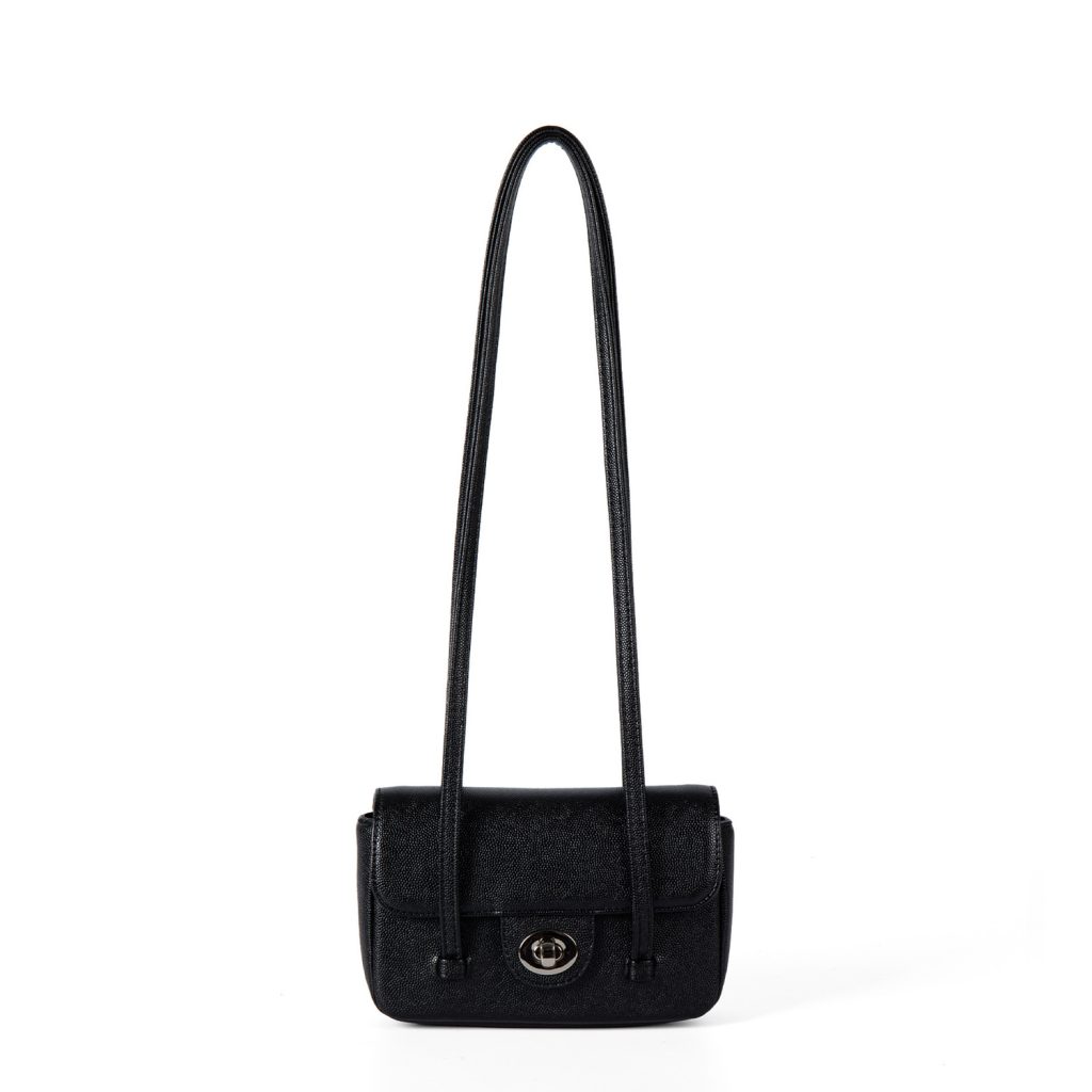 A dusty pink pebbled vegan leather baguette with a silver turn-lock flap and two long thin shoulder straps.