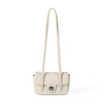 A dusty pink pebbled vegan leather baguette with a silver turn-lock flap and two long thin shoulder straps. Additional product view 3.