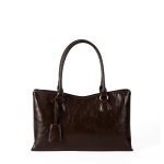 A black vegan leather shoulder tote with a gently scooped top, tubular handles, and a matching hanging leather tag. Additional product view 2.