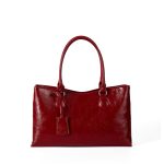 A black vegan leather shoulder tote with a gently scooped top, tubular handles, and a matching hanging leather tag. Additional product view 3.