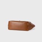 A slouchy black vegan leather tote with integrated shoulder straps and a thin vertical strap finished with a silver buckle. Additional product view 6.