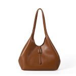A slouchy black vegan leather tote with integrated shoulder straps and a thin vertical strap finished with a silver buckle. Additional product view 3.
