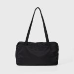 A black polyester rectangular shoulder bag with two buttoned cargo pockets edged in white lace and a top zipper. Additional product view 6.
