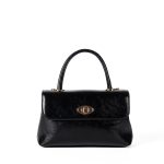 A dark brown glossy vegan leather top-handle flap bag with a gold-tone oval twist-lock centered on the front. Additional product view 4.
