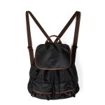 A black nylon backpack with cognac brown vegan leather piping, a top flap over a drawstring, and two lower front pockets.