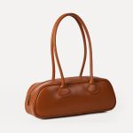 A long black vegan leather east-west baguette with two thin tubular straps and a silver zipper along the top. Additional product view 5.