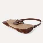 A beige woven canvas baguette with dark brown vegan leather corner patches, a center buckle strap, and a slim shoulder strap. Additional product view 8.