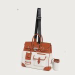 A large black utility tote with mixed canvas and vegan leather panels, multiple cargo pockets, and a silver turn-lock. Additional product view 7.
