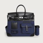 A large black utility tote with mixed canvas and vegan leather panels, multiple cargo pockets, and a silver turn-lock. Additional product view 3.