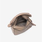 A light beige pebbled vegan leather puzzle bag with diagonal panels, a rolled top handle, and an adjustable shoulder strap. Additional product view 6.