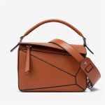 A light beige pebbled vegan leather puzzle bag with diagonal panels, a rolled top handle, and an adjustable shoulder strap. Additional product view 4.