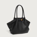 A large off-white pebbled vegan leather tote with folded winged sides, slim shoulder straps, and a gold center clasp. Additional product view 5.